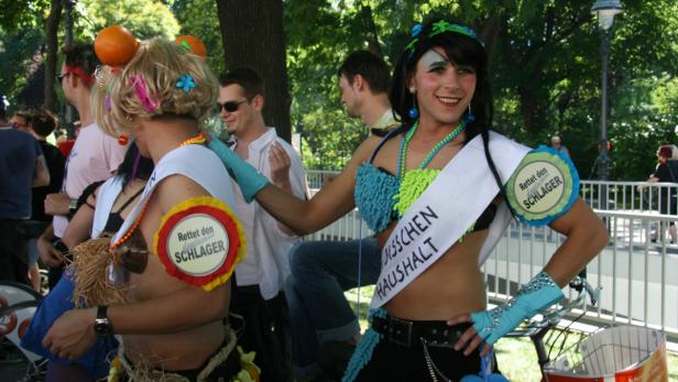 Zwei Menschen in auffälligen Kostümen nehmen an einer Parade teil.