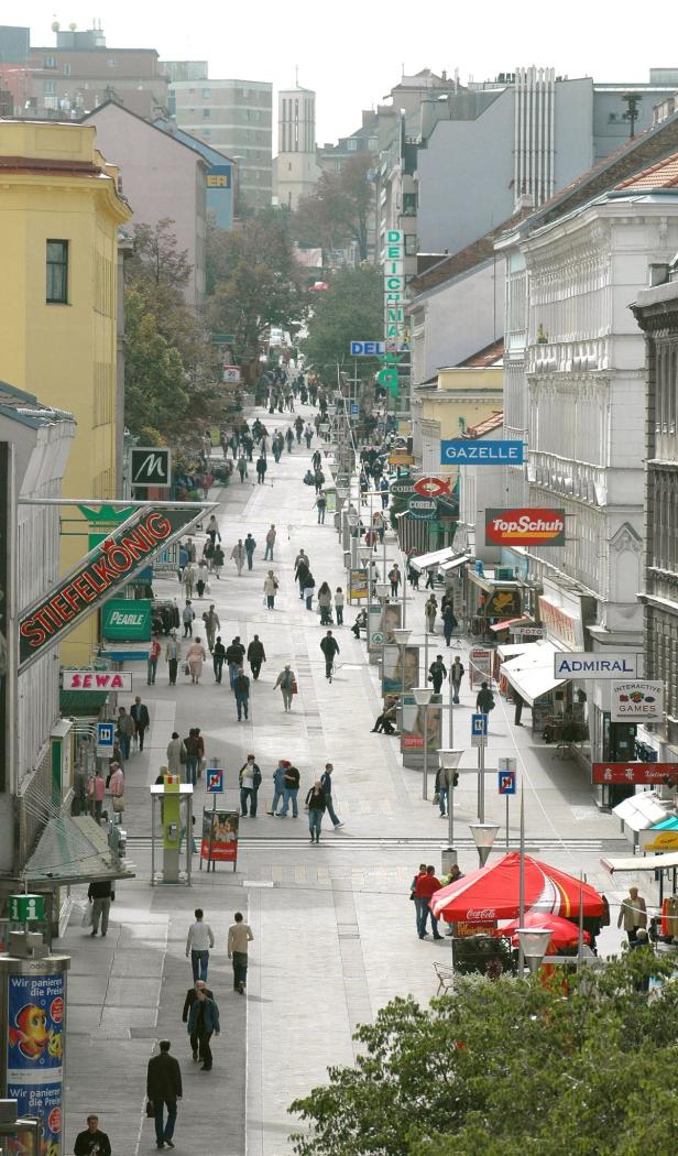 Blick auf eine belebte Einkaufsstraße mit vielen Passanten und Geschäften.