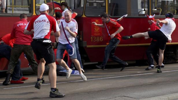 Fußballfans verschiedener Nationalitäten geraten an einer Straßenbahnhaltestelle aneinander.