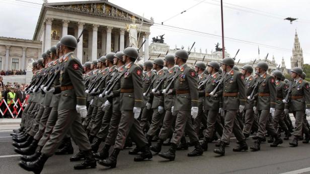 Eine Reihe österreichischer Soldaten marschiert vor dem Parlament in Wien.