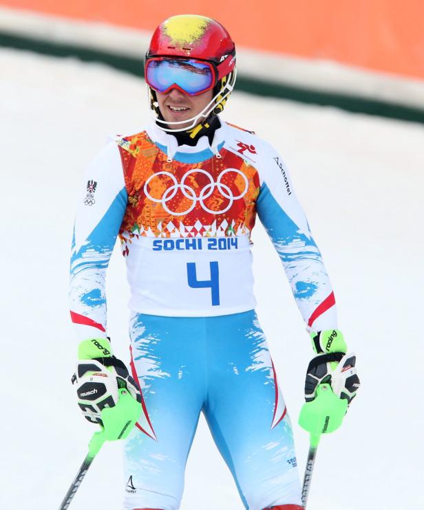 Ein Skirennläufer mit Helm und Skibrille in Rennkleidung mit der Nummer 4.