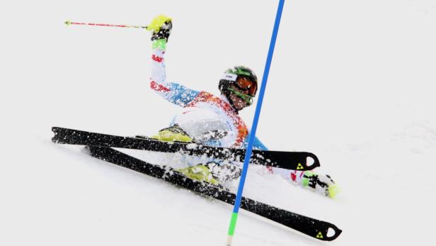 Ein Skifahrer stürzt während eines Rennens im Schnee.