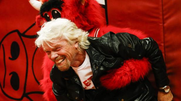 Richard Branson wird von dem Maskottchen der Chicago Bulls umarmt.