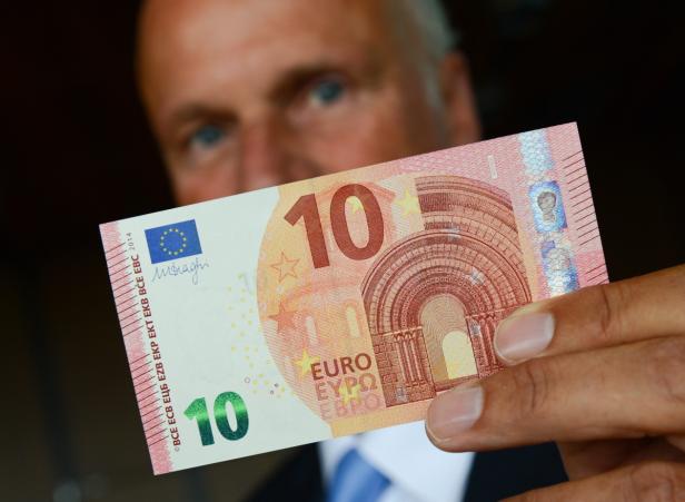 Eine Person hält einen 10-Euro-Schein in der Hand.