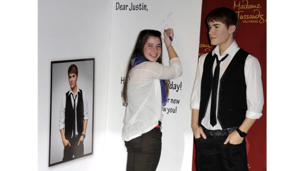 Ein Fan schreibt eine Nachricht an Justin Bieber neben seiner Wachsfigur bei Madame Tussauds.
