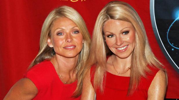 Kelly Ripa posiert neben ihrer Wachsfigur in einem roten Kleid.