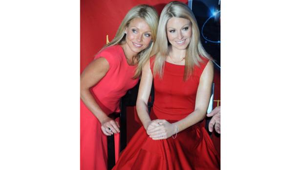 Kelly Ripa posiert neben ihrer Wachsfigur in einem roten Kleid.