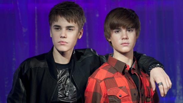 Justin Bieber steht neben seiner Wachsfigur.