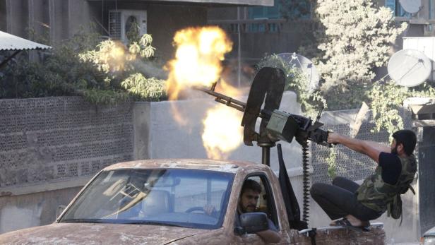 Ein Mitglied der syrischen Rebellen feuert auf einen Stützpunkt der Armee in Aleppo.