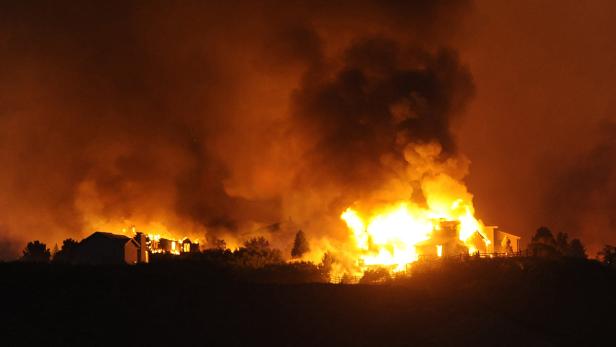 Ein Gebäude steht in Flammen, Rauch steigt in den dunklen Nachthimmel.