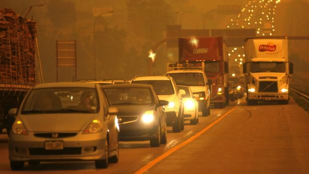 Starker Verkehr mit Autos und Lastwagen auf einer Autobahn bei schlechter Sicht.