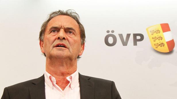 Ein Mann in Anzug steht vor einem ÖVP-Logo.
