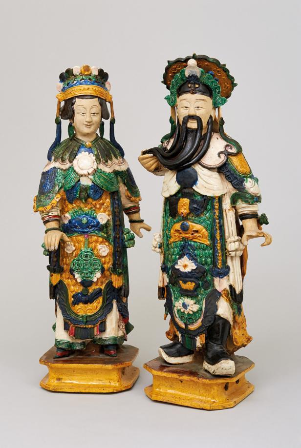 Zwei farbenfrohe chinesische Statuen von einem Mann und einer Frau auf goldenen Sockeln.