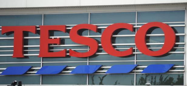 BRITAIN ECONOMY Das rote Tesco-Logo an der Fassade eines Geschäftsgebäudes.