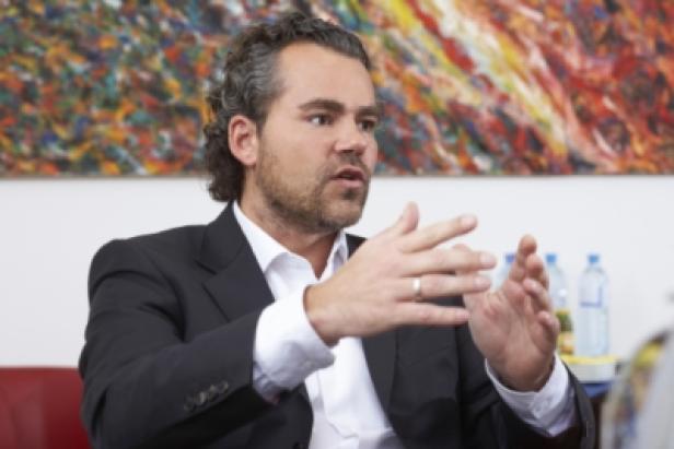 Christoph Payer, Geschäftsführer und Eigentümer extragolf.at (c: extrgolf/polster) Ein Mann im Anzug gestikuliert während eines Gesprächs.