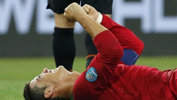 Ein Fußballspieler liegt auf dem Rücken und jubelt mit geballten Fäusten.