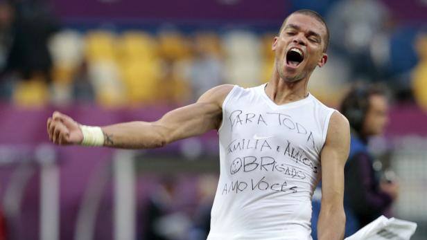 Ein jubelnder Fußballspieler mit einem T-Shirt, auf dem „Para toda familia e amigos obrigado amo voces“ steht.
