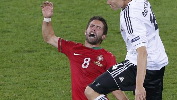 Ein portugiesischer Fußballspieler schreit vor Schmerz nach einem Zusammenstoß mit einem deutschen Spieler.