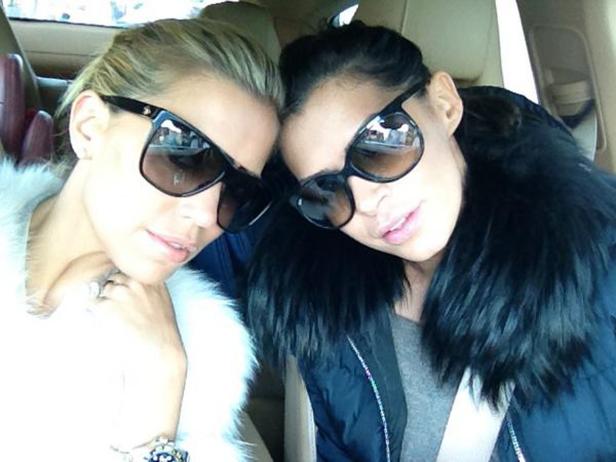 Zwei Frauen mit Sonnenbrillen posieren für ein Selfie in einem Auto.