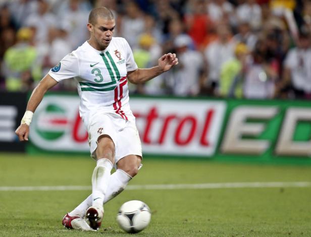 Ein Fußballspieler in einem weißen Trikot mit der Nummer 3 schießt einen Ball.