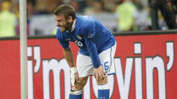 Ein italienischer Fußballspieler mit schmerzverzerrtem Gesicht während eines Spiels.