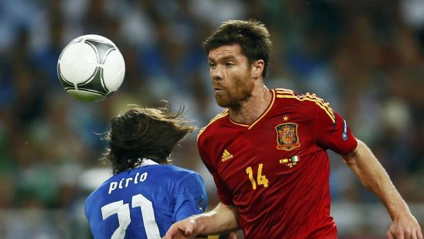 Xabi Alonso von Spanien köpft den Ball, während Andrea Pirlo von Italien zusieht.
