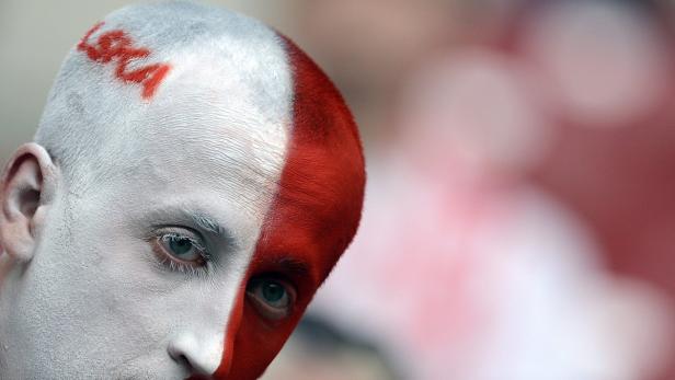 Ein Mann mit weißer und roter Farbe im Gesicht und dem Wort „LECHA“ auf dem Kopf.