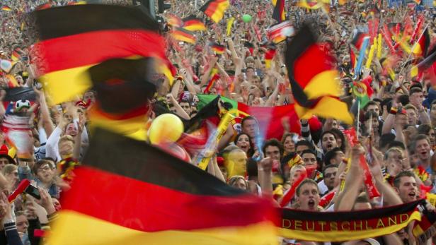 Eine große Menschenmenge schwenkt Deutschland-Flaggen und jubelt.