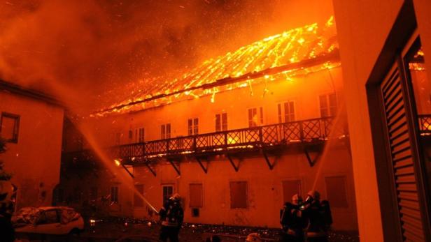 Feuerwehrleute bekämpfen einen Brand in einem mehrstöckigen Gebäude.