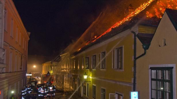 Ein brennendes Gebäude wird von Feuerwehrleuten gelöscht.
