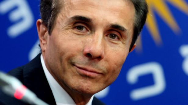 Ein Porträt von Bidzina Ivanishvili vor einem blauen Hintergrund.