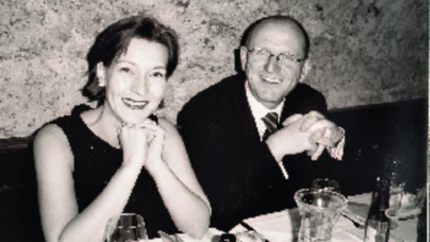 Ein Mann und eine Frau sitzen lächelnd an einem Tisch in einem Restaurant.