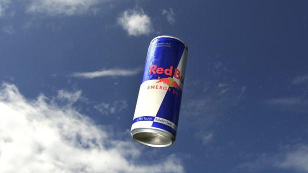 Eine Dose Red Bull Energy Drink vor blauem Himmel mit Wolken.