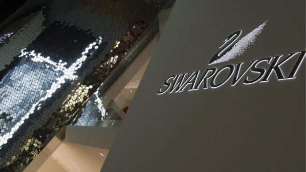 Das Swarovski-Logo an einer Wand neben einer glitzernden Dekoration.