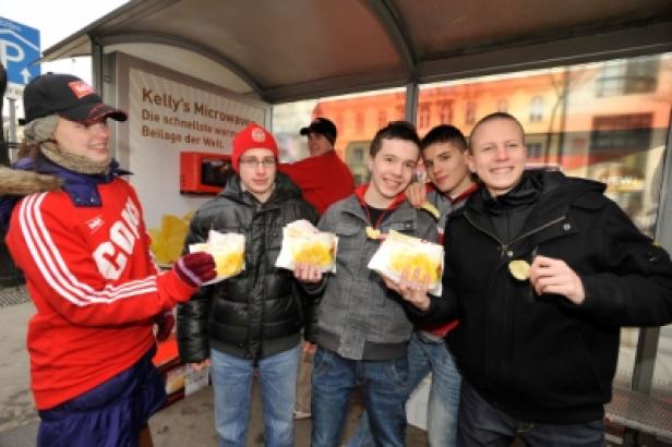 Eine Gruppe junger Männer hält Tüten mit Kelly's Mikrowellen-Popcorn in der Hand.