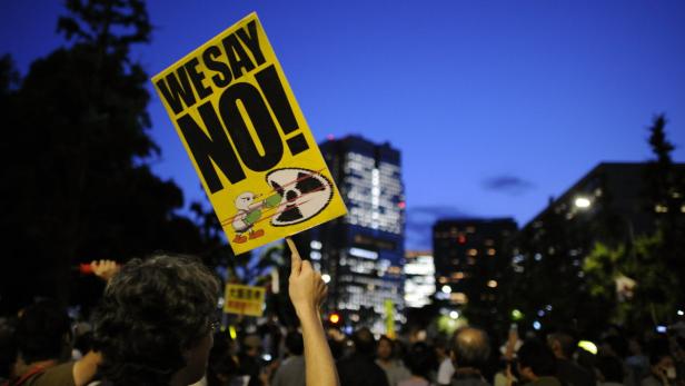 Eine Person hält ein Schild mit der Aufschrift „We say NO!“ bei einer Demonstration.