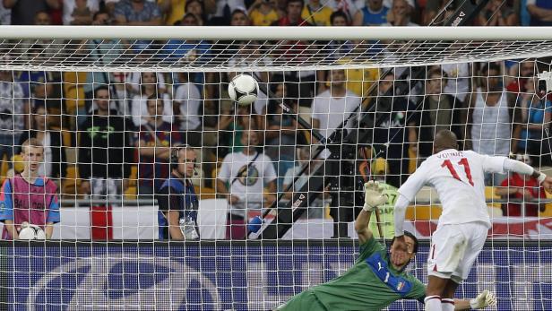 Ein Fußball fliegt ins Tor, während ein Torwart versucht, ihn abzuwehren.