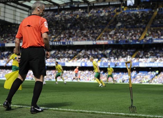 Ein Linienrichter steht während eines Fußballspiels auf dem Spielfeld.