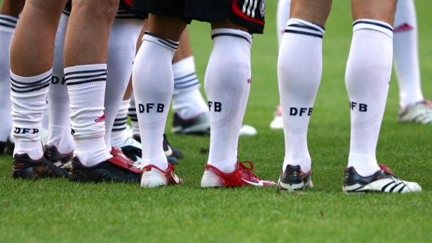 Mehrere Fußballspieler der deutschen Nationalmannschaft stehen auf dem Rasen.