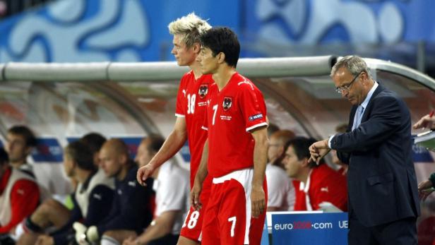 Zwei österreichische Fußballspieler und ein Trainer am Spielfeldrand.