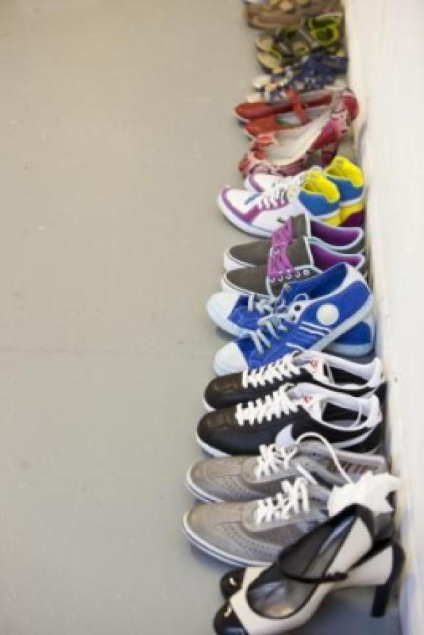 Eine Reihe verschiedener Schuhe steht an einer Wand.
