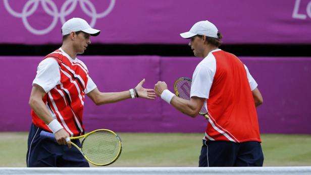REUTERSMike Bryan (R) and Bob Bryan of the U.S. bump hands during their mens doubles tennis gold medal match against Frances Jo-Wilfried Tsonga (not shown) and Michael Llodra (L) at the All England Lawn Tennis Club during the London 2012 Olympic Games Aug