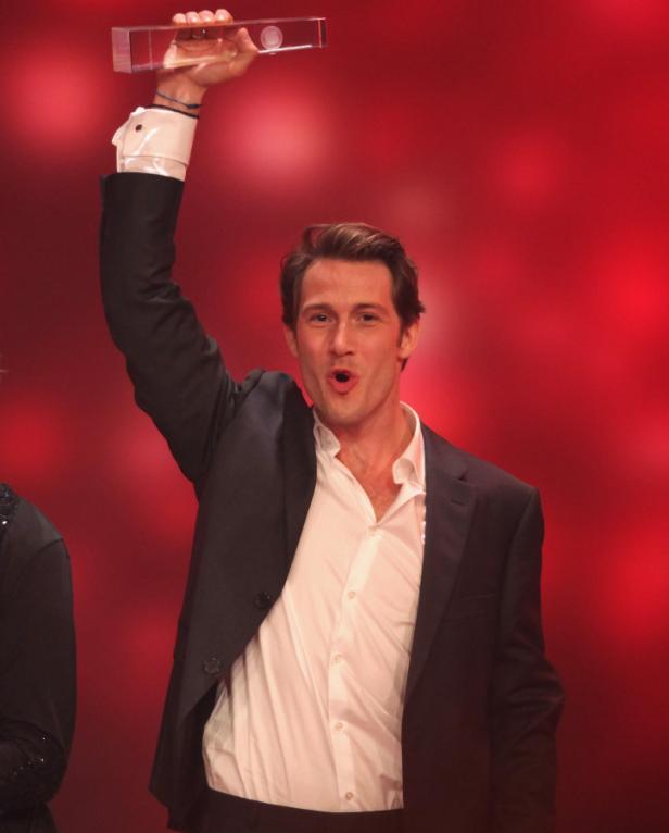 Matthias Schweighöfer hält einen Preis in die Höhe.