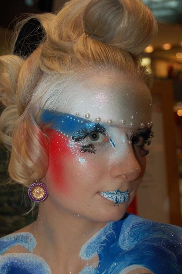 Eine Frau mit aufwendigem Make-up in den Farben Rot, Weiß und Blau.