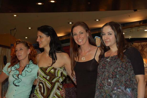 Vier Frauen posieren nebeneinander für ein Foto.