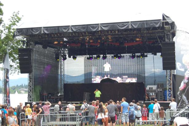 Eine Menschenmenge vor einer Bühne mit zwei Sängern während eines Konzerts.