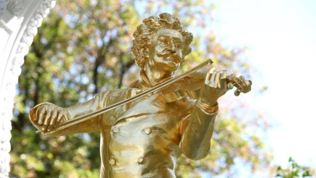 Eine goldene Statue von Johann Strauss spielt Geige.
