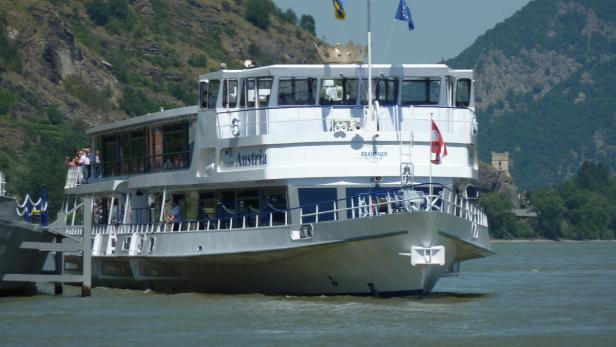 Das Ausflugsschiff „Austria“ auf einem Fluss mit bewaldeten Hügeln im Hintergrund.