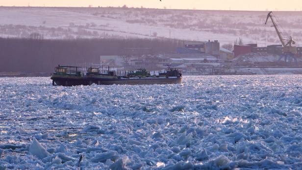 Ein Schiff fährt durch ein mit Eisschollen bedecktes Gewässer.