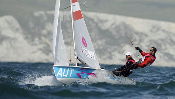 Zwei Segler auf einem Segelboot mit der Aufschrift „AUT“ bei den Olympischen Spielen 2012 in London.